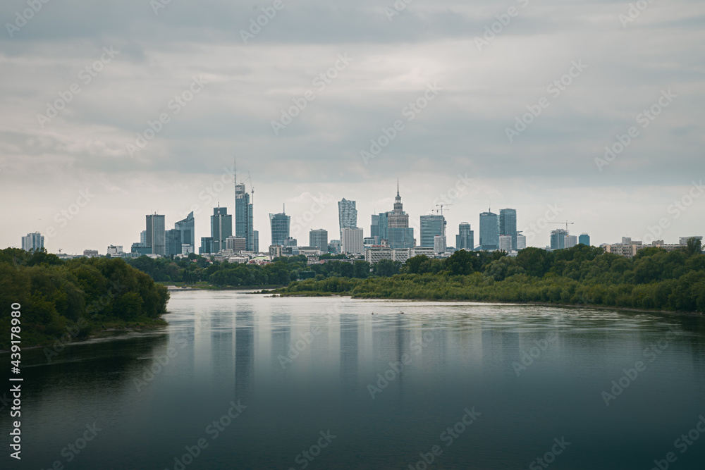 Skyline of the city of Warsaw, the capital of Poland, in which we can see the most emblematic buildings. Reflection on the river Vistula, cloudy day Wisla.