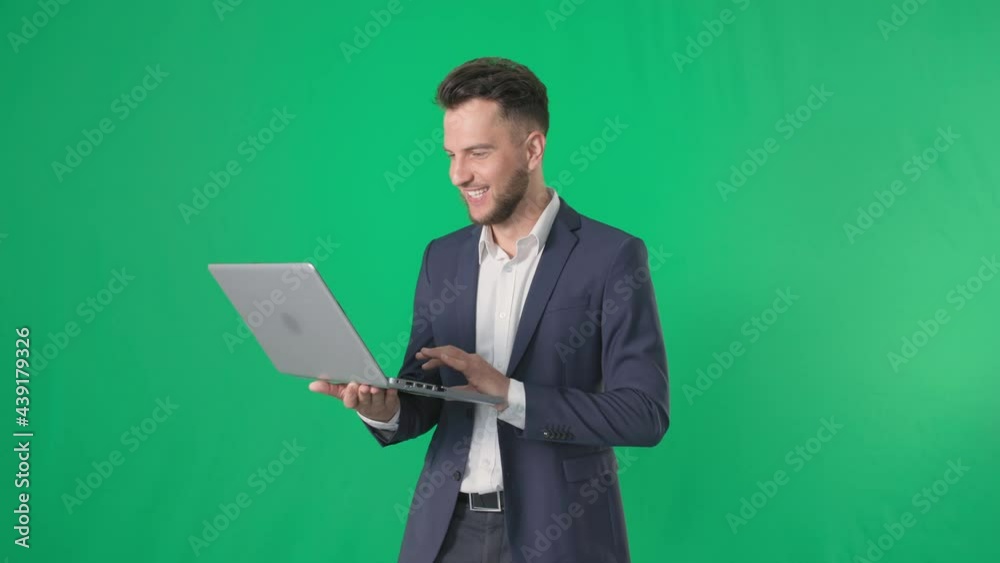 small business, charming male manager catches laptop for joy smiling and looking at camera on green background, chroma key small business, charming male manager catches laptop for joy smiling and looking at camera on green background, chroma key