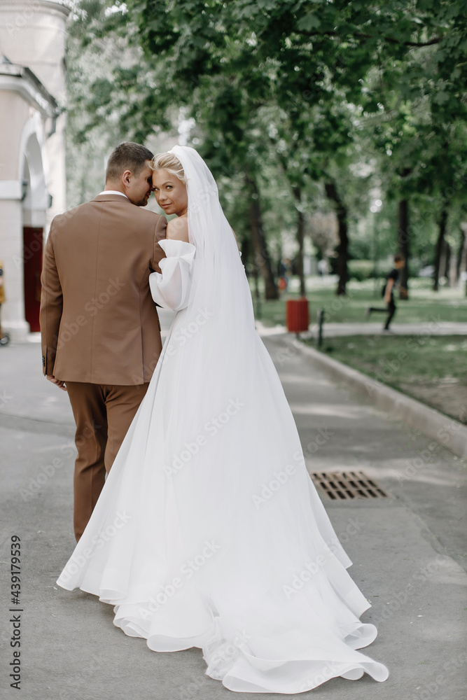 the groom and the bride walk in the park