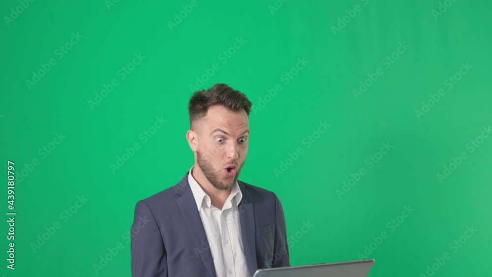 portrait of a man businessman in a business suit catches a laptop smiling and looks at the camera on a green screen, chrome key portrait of a man businessman in a business suit catches a laptop smiling and looks at the camera on a green screen, chrome key
