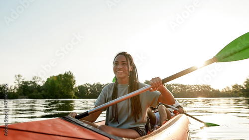 Fotografie Active young woman smiling, enjoying a day kayaking together with her boyfriend