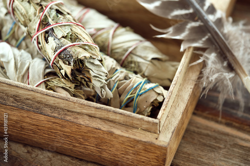 Smudge Sticks (Kräuterbündel) Weißer Salbei, Yerba Santa in Holzbox mit Räucherfeder, Close-up photo
