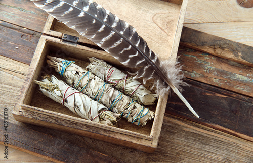Smudge Sticks White Sage (Kräuterbündel Weißer Salbei), Yerba Santa in Holzbox mit Räucherfeder, Top view photo