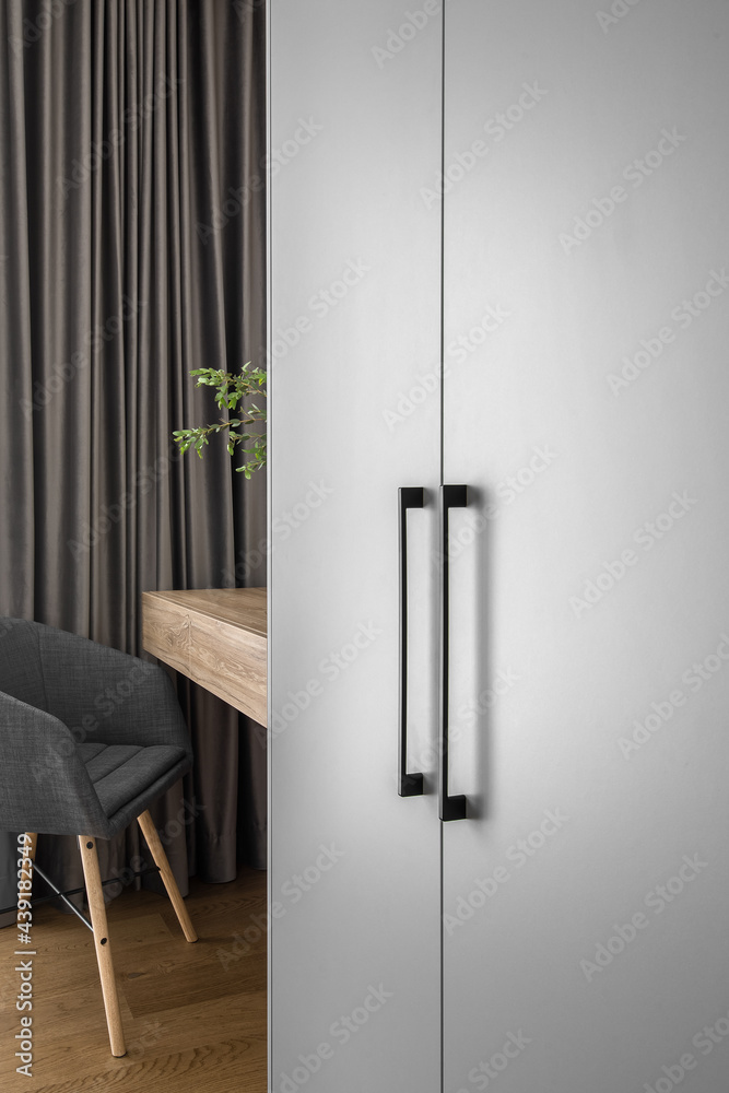 Elegant mirror on wooden frame wall above minimal wood console table in trendy bedroom interior of grey tones Elegant mirror on wooden frame wall above minimal wood console table in trendy bedroom interior of grey tones