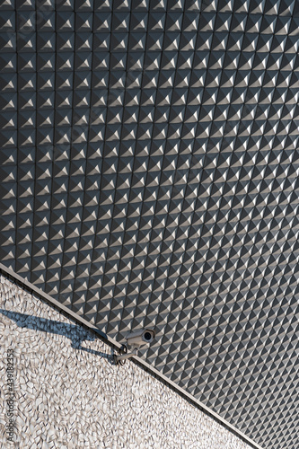 Obraz na płótnie Street camera attached to a building, geometric elevation tiles in background w salonie
