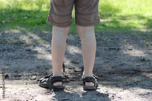 Enfant garçon en short et sandales se promène dans le parc jardin été printemps 