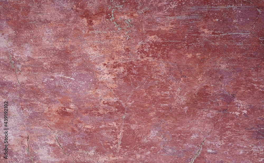 Fototapeta premium closeup of a distressed wall in pink and red shades 
