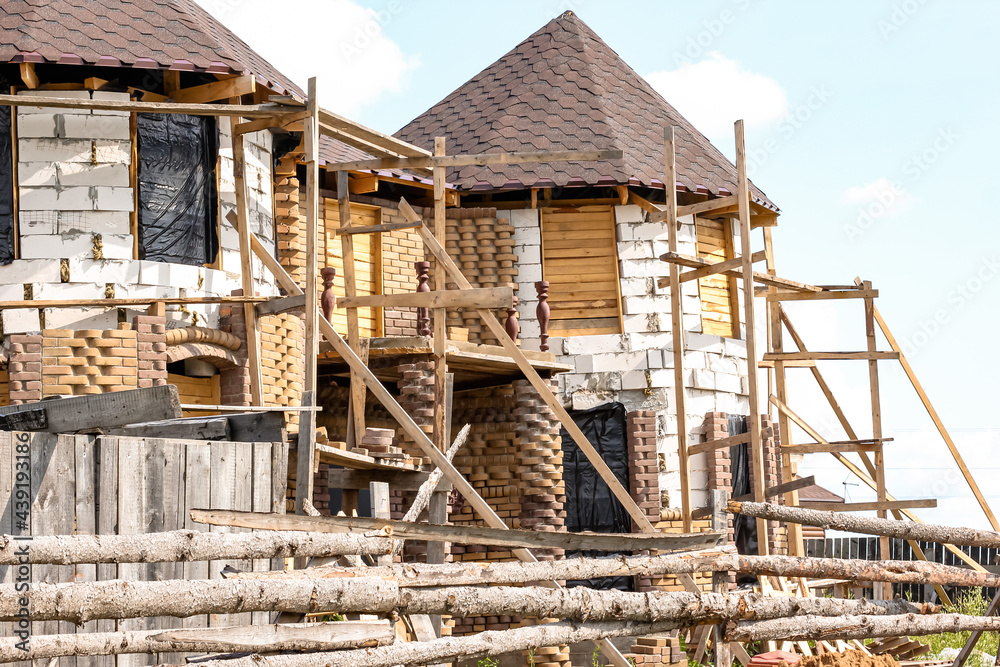 Obraz premium Unfinished white brick building. Foam block cottage. Construction and architectureof houses. 