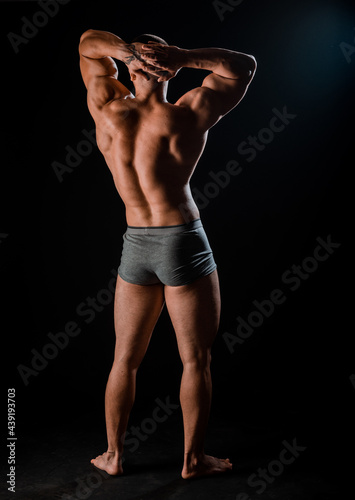 Young bodybuider with tattoos posing in studio photo