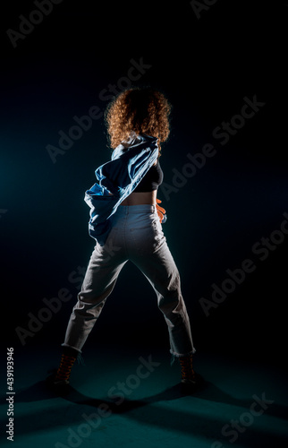 Young dance artist perform acrobat moves isolated on dark background