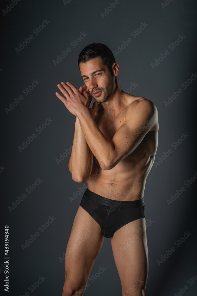 Fashion close-up portrait of a handsome male with bare torso posing in black underwear on isolated background Fashion close-up portrait of a handsome male with bare torso posing in black underwear on isolated background