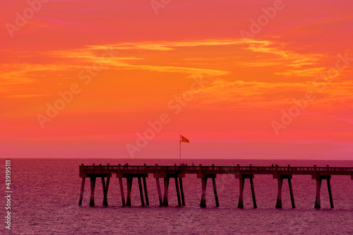 Orange and pink sunset over a pier