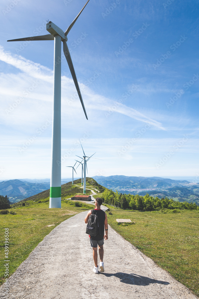 Obraz premium Young caucasian man near windmills at the top of Oiz mountain; Basque Country.