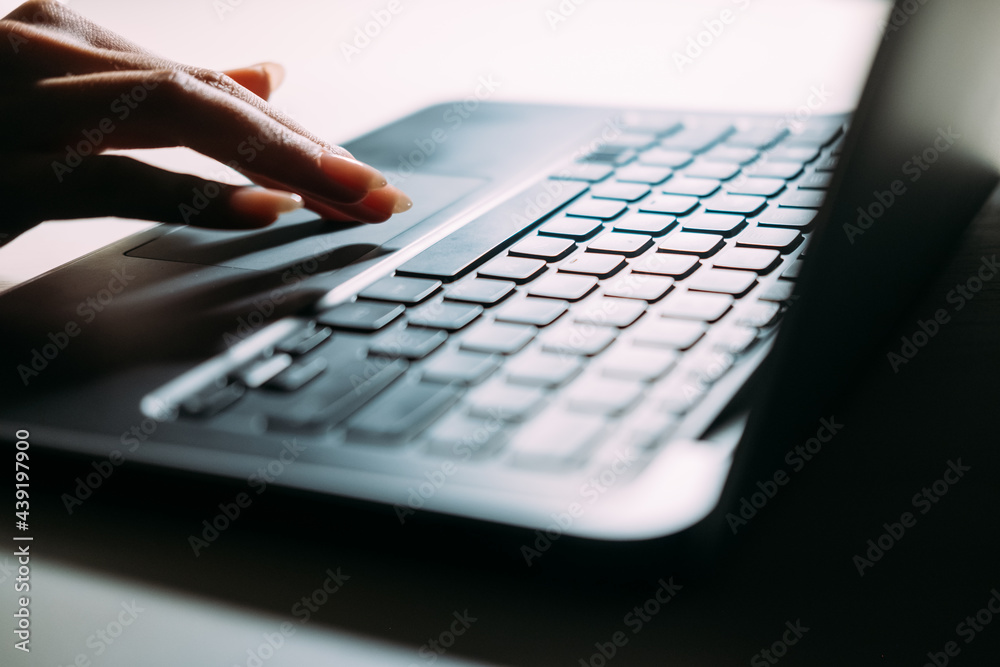 Virtual searching. Internet technology. Laptop working. Digital lifestyle. Unrecognizable woman scrolling portable computer touch pad light lamp dark shadow. Virtual searching. Internet technology. Laptop working. Digital lifestyle. Unrecognizable woman scrolling portable computer touch pad light lamp dark shadow.
