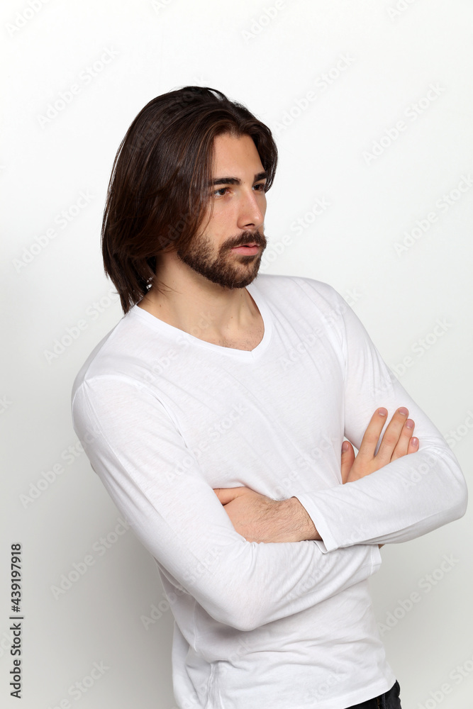 Attractive male model with long hair and beard posing in studio on isolated background. Style, trends, fashion concept. Attractive male model with long hair and beard posing in studio on isolated background. Style, trends, fashion concept.