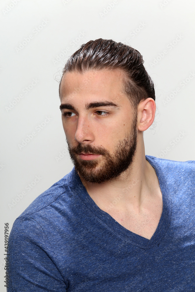 Attractive male model with long hair and beard posing in studio on isolated background. Style, trends, fashion concept. Attractive male model with long hair and beard posing in studio on isolated background. Style, trends, fashion concept.