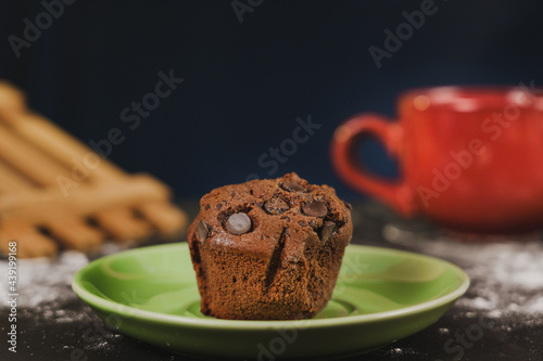 Homemade chocolate chips and vanilla muffin on a black background with sugar
