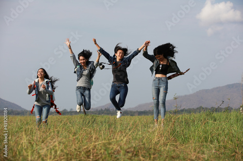 Happy and funny teenger woman jump up over the grass field in forest