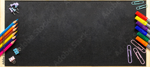 School office supplies. Various stationery: pencils, felt-tip pens, paper clips. School blackboard in wooden frame. Back to school and new academic year concept. Extra wide banner. Copy space