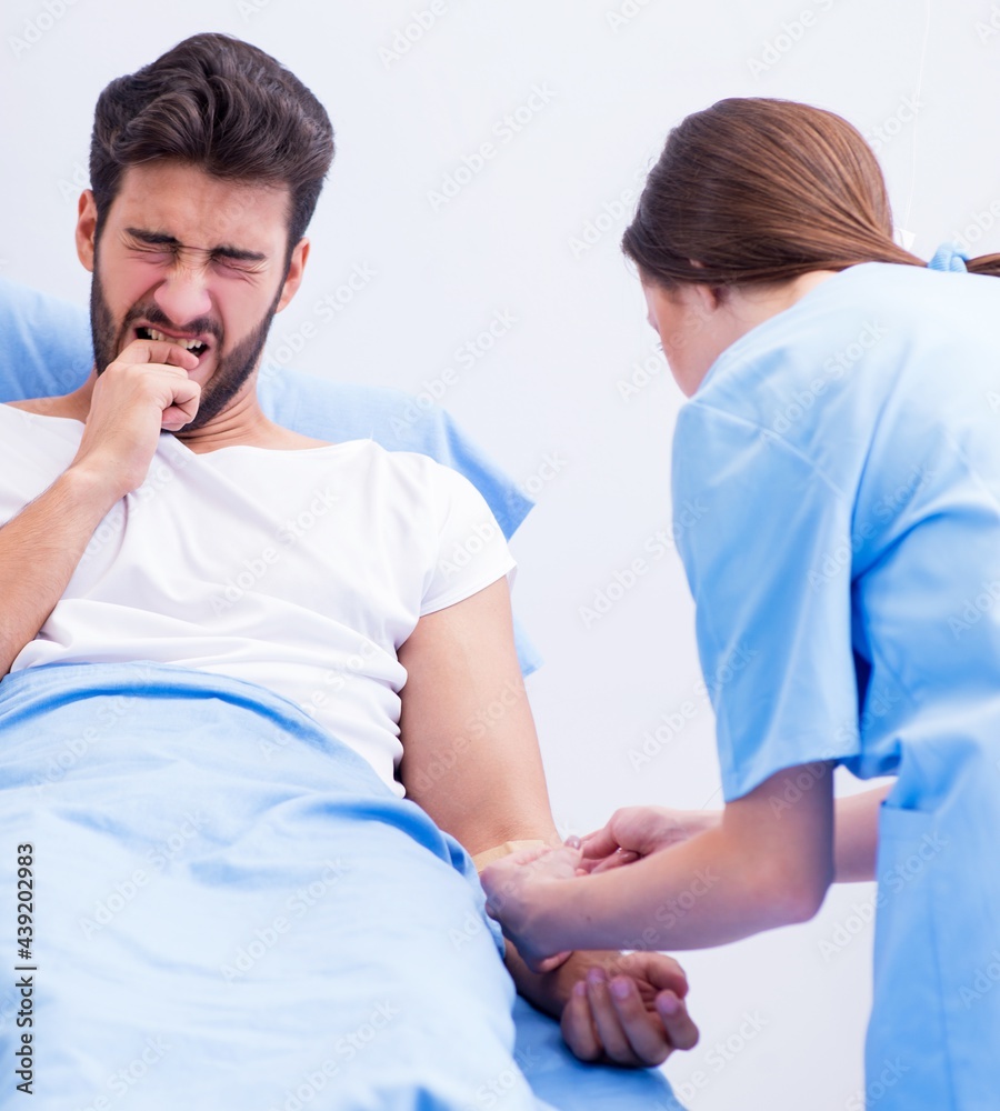 Woman doctor examining male patient in hospital Woman doctor examining male patient in hospital