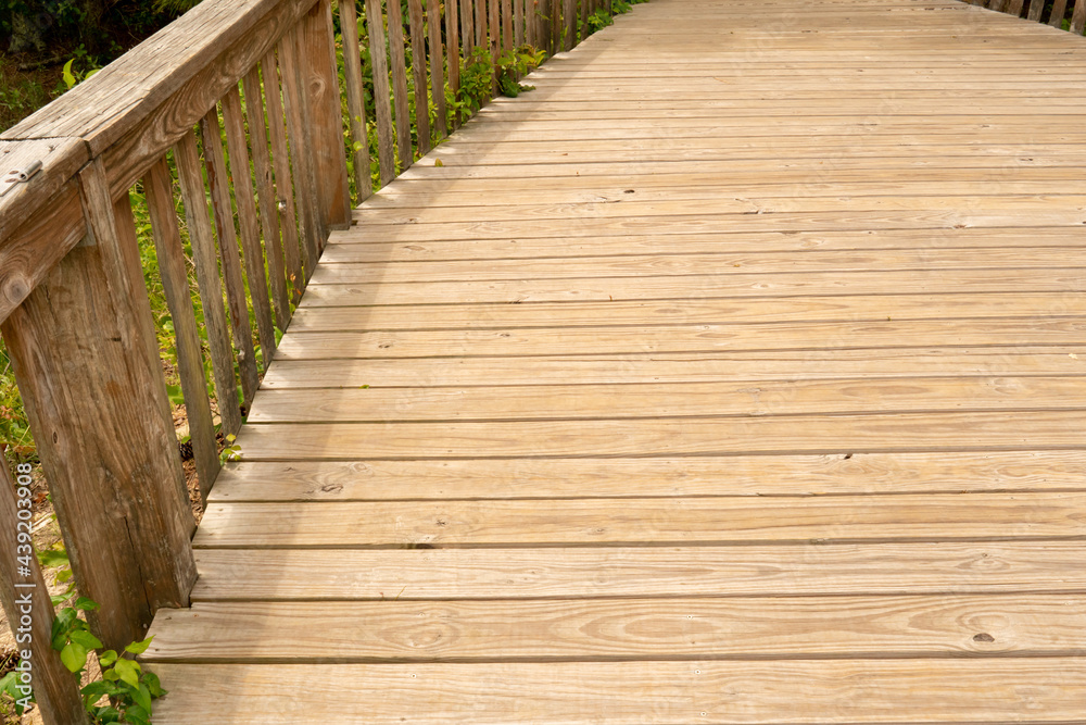 Bare untreated unsealed, unprotected pressure treated wooden floor boards of outdoor deck for entertaining guests in backyard property with hand railing Bare untreated unsealed, unprotected pressure treated wooden floor boards of outdoor deck for entertaining guests in backyard property with hand railing