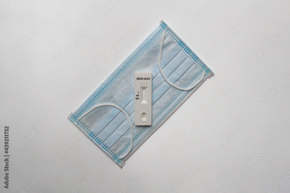 Covid-19 PCR test and medical face mask isolated on white background from a high angle view Covid-19 PCR test and medical face mask isolated on white background from a high angle view