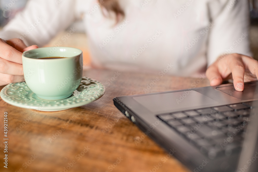 Young woman working while drinking coffee at home Young woman working while drinking coffee at home