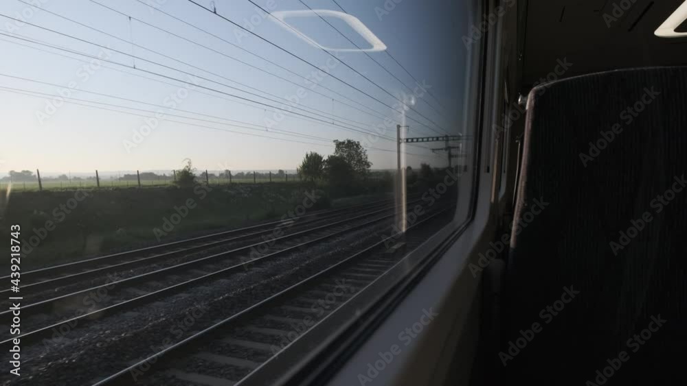 Looking out the window of high speed train at english countryside early morning empty seat