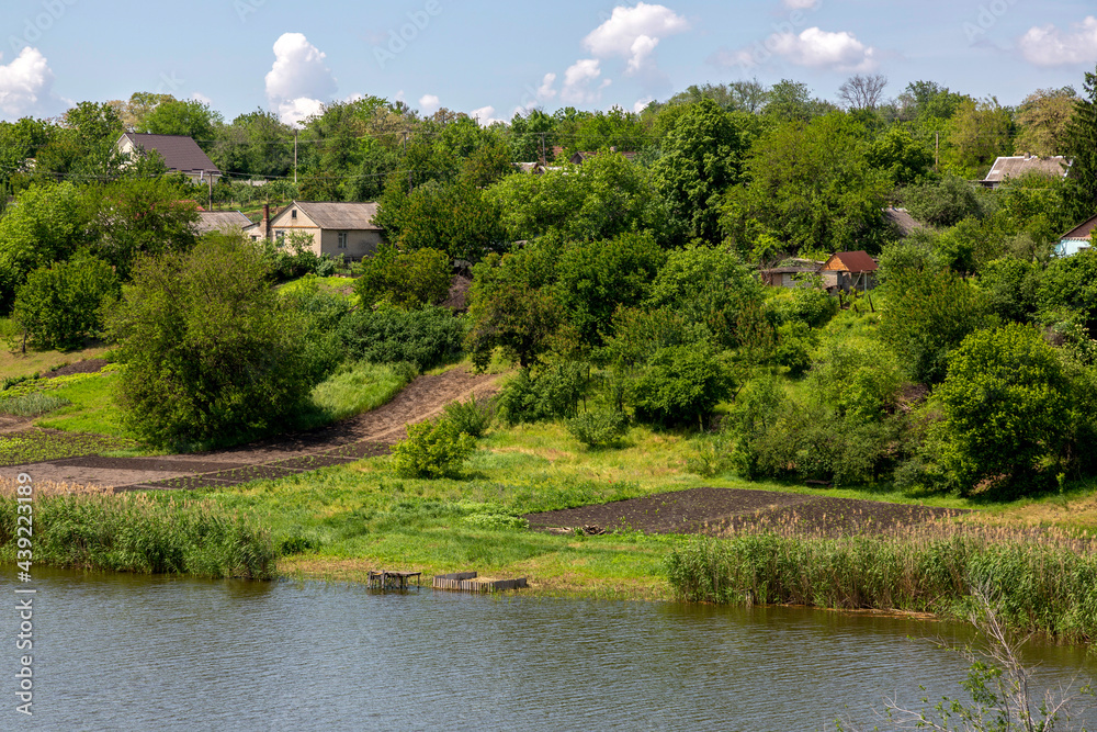 Panorama with a rural landscape. Sura river and Novonikolaevka village in Ukraine
