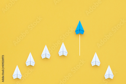 Business concept for new ideas creativity, innovative solution and Leadership concept with blue paper plane leading among white on yellow background photo