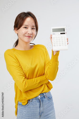 여자, 사람, 인물사진, 서있는, 노란색 니트, 스웨터, 표정, 미소, 웃는, 기쁨, 놀람, 귀여운, 학생, 계산기, 계산, 정산, 손동작