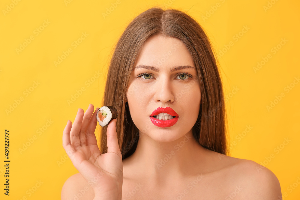 Beautiful young woman with tasty sushi roll on color background Beautiful young woman with tasty sushi roll on color background
