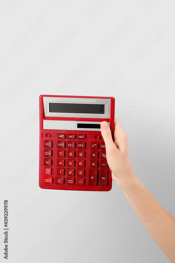 woman with calculator on light background