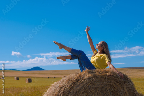 a girl is sunbathing in the hay. village life: harvesting hay for the winter. animal feed.