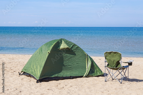 travel to the sea. tent and camping chair on the beach.