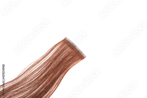 Fake brown hair on sticky tape on white isolated background. High quality photo