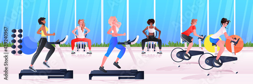 sports women group doing physical exercises mix race girls training in gym aerobic workout healthy lifestyle concept