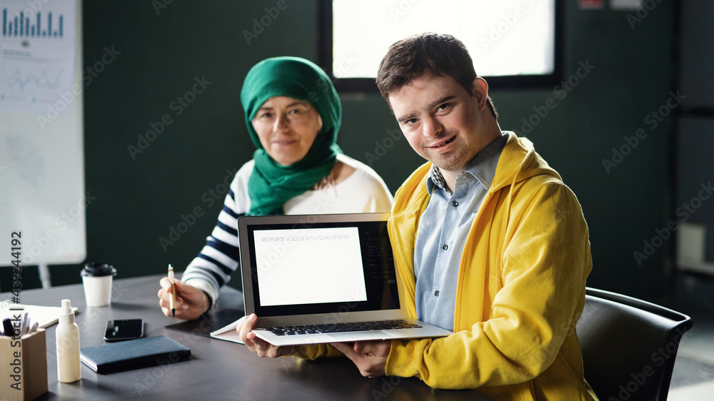 Down-syndrome man attending education class in community center, inclusivity of disabled person. Down-syndrome man attending education class in community center, inclusivity of disabled person.