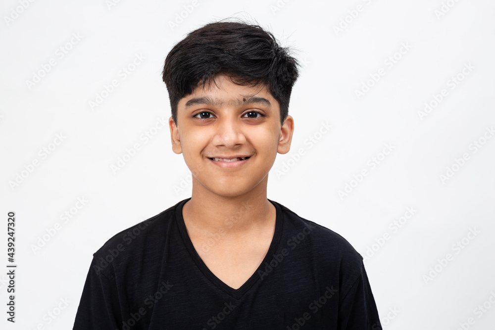 Close up pic of a cute Indian boy. Adorable teenager standing against white backdrop Close up pic of a cute Indian boy. Adorable teenager standing against white backdrop