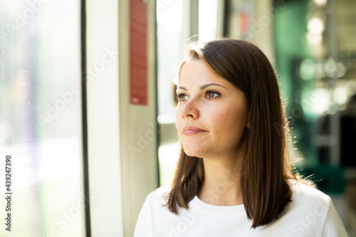 Free Download Portrait of positive girl passenger enjoying trip at public transport in modern tram - GFXLoad