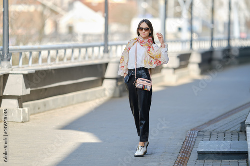 Cheerful woman walking on the bridge in sunny day