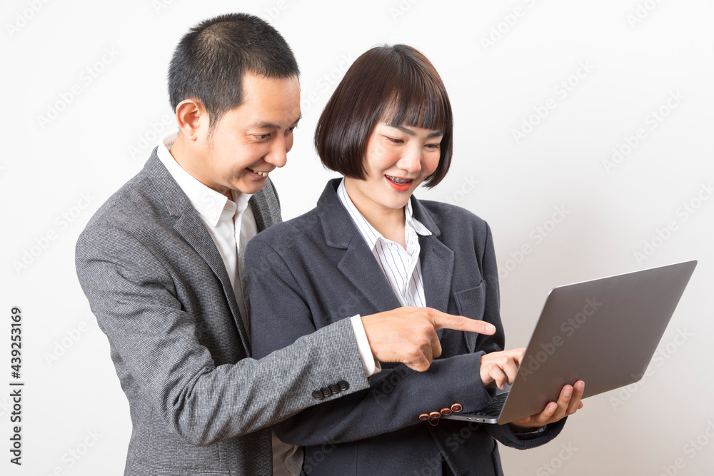 Asian businesswoman and businessman holding computer standing on white background. Asian businesswoman and businessman holding computer standing on white background.