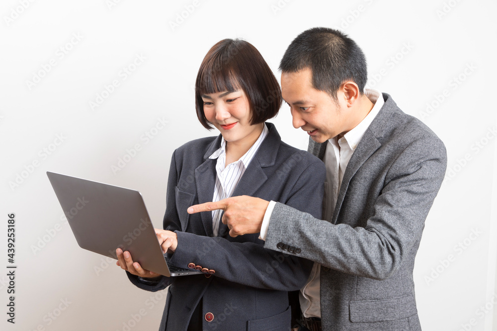 Asian businesswoman and businessman holding computer standing on white background. Asian businesswoman and businessman holding computer standing on white background.