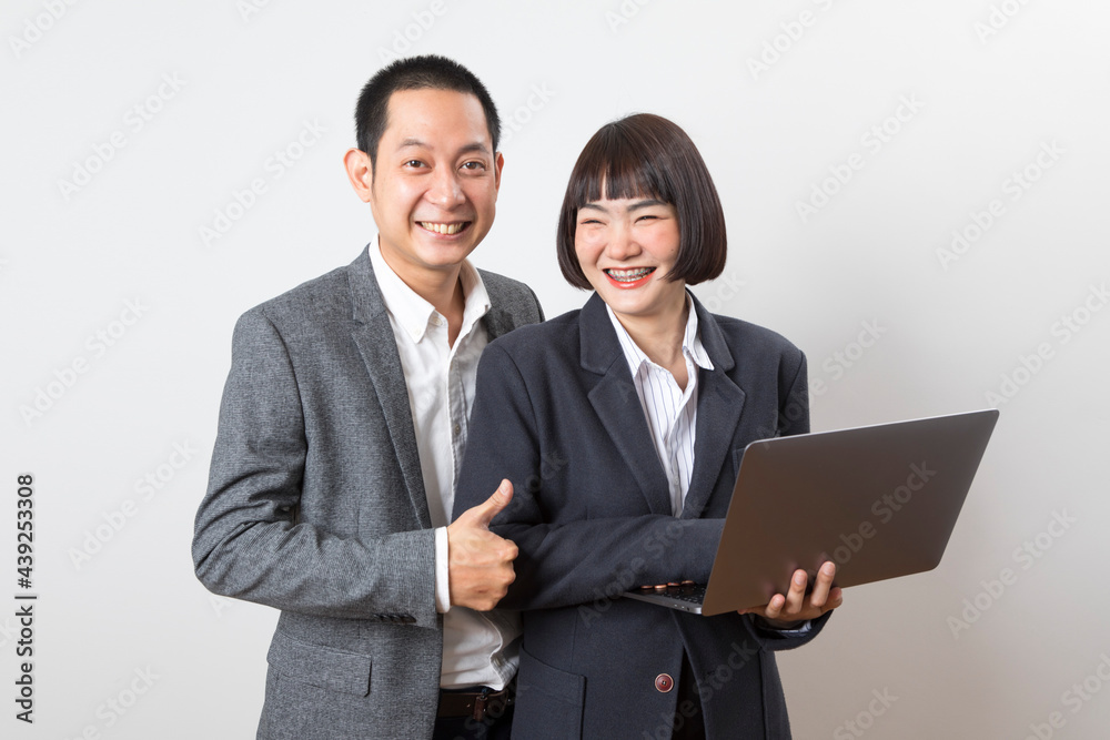 Asian businesswoman and businessman holding computer standing on white background. Asian businesswoman and businessman holding computer standing on white background.