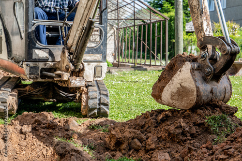 Canvastavla Mini excavator with excavated pile of earth