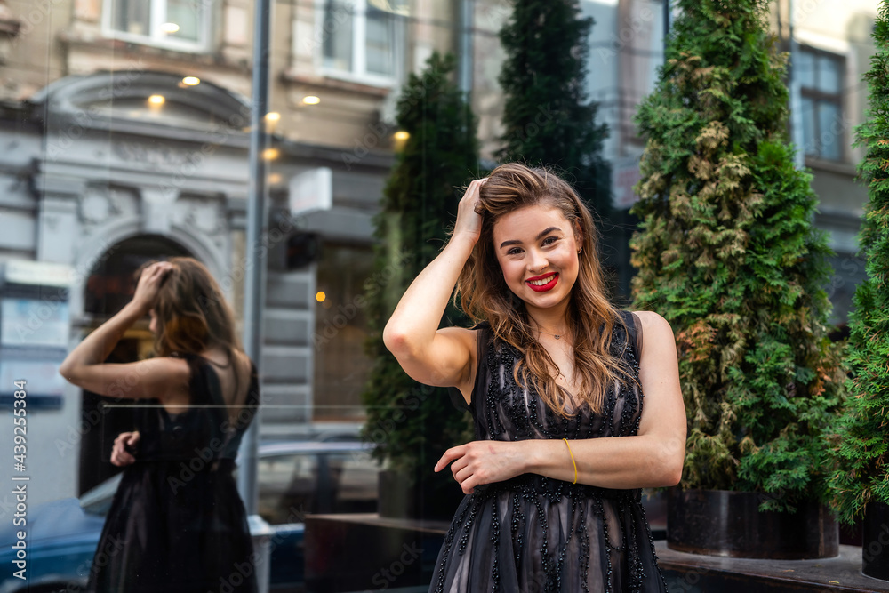 Fototapeta premium Portrait of pretty lady in evening black dress in outdoor