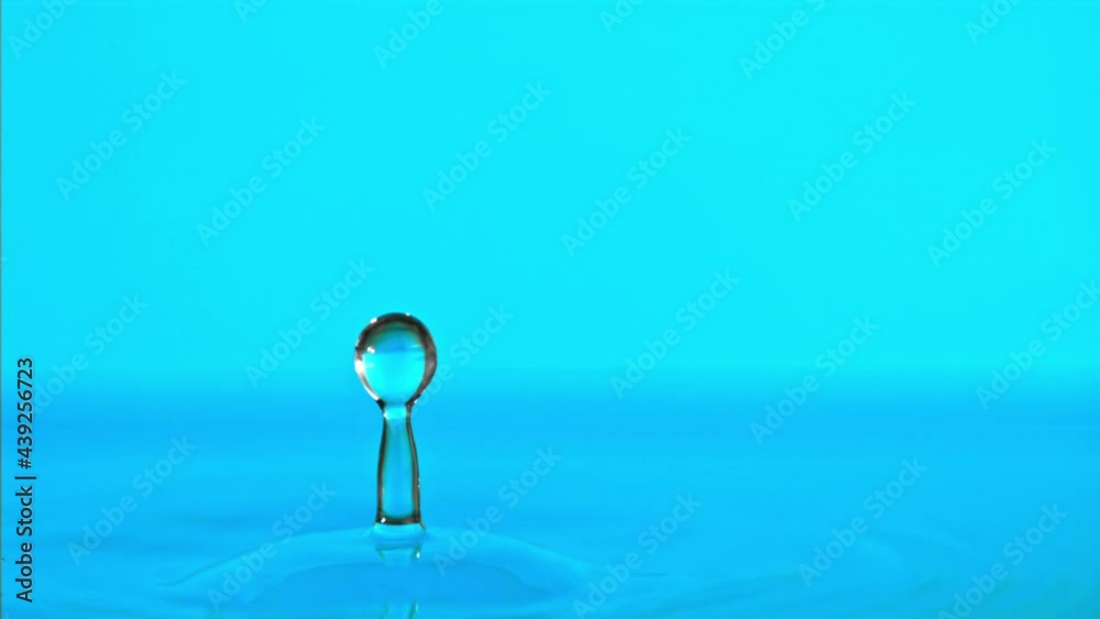 Super slow motion water falls on the table on a blue background. Filmed on a high-speed camera at 1000 fps. High quality FullHD footage