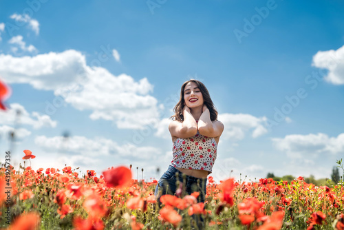 Fototapeta Naklejka Na Ścianę i Meble -  portrait of young girl at the red poppies field