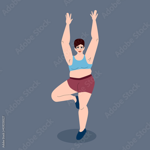 Body positive. A woman does yoga. The girl is full-length, standing on one leg, hands above her head. Beautiful plus-size female figure. Sports activities.
