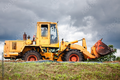 A yellow bulldozer at work, high on a hill.